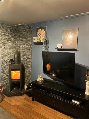 a living room with a flat screen tv and a fireplace at Sentrumsnært hus in Rjukan