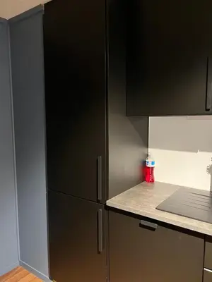 a kitchen with black cabinets and a counter top at Sentrumsnært hus in Rjukan