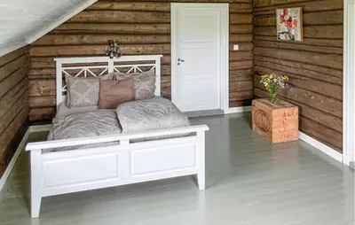 a white bed in a room with wooden walls at Gorgeous Home In Svatsum With Wifi in Svingvoll