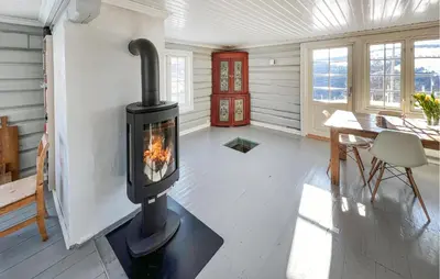 a wood stove in a room with a table at Gorgeous Home In Svatsum With Wifi in Svingvoll