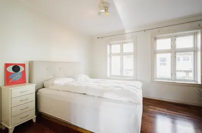 a white bedroom with a bed and two windows at The View - BIG Apartment in City Center in Bergen