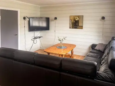 a living room with a black couch and a table at 8 person holiday home in Flatraket-By Traum in Barmen