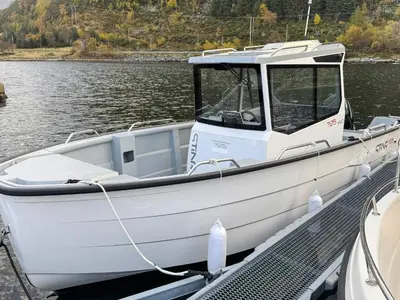 a white boat docked at a dock in the water at 8 person holiday home in Flatraket-By Traum in Barmen