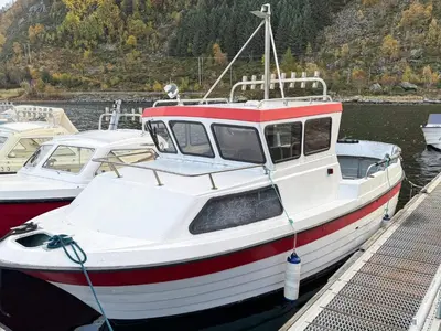 a red and white boat is docked at a dock at 8 person holiday home in Flatraket-By Traum in Barmen
