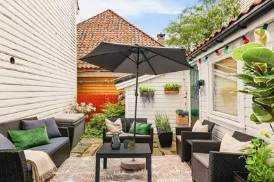 a patio with a table and an umbrella at Dinbnb Apartments I Family Dream in Bergen I Playroom I Private Garden in Bergen