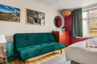 a green couch in a bedroom with a bed at Dinbnb Apartments I Family Dream in Bergen I Playroom I Private Garden in Bergen