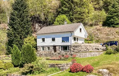 a white house on top of a hill at 4 Bedroom Awesome Home In Nedre Vats in Stokka