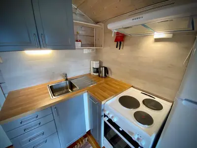 a small kitchen with a stove and a sink at Hole Hytter in Geiranger