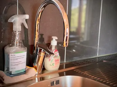 a sink with two bottles of detergent and a mirror at Hole Hytter in Geiranger