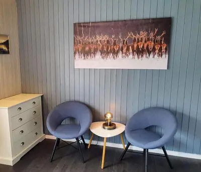 two blue chairs and a table in a room at Dalsøren Camping og hytter in Luster