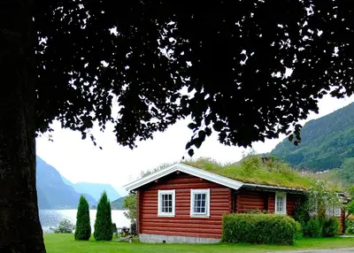 a small wooden cabin with a grass roof at Dalsøren Camping og hytter in Luster