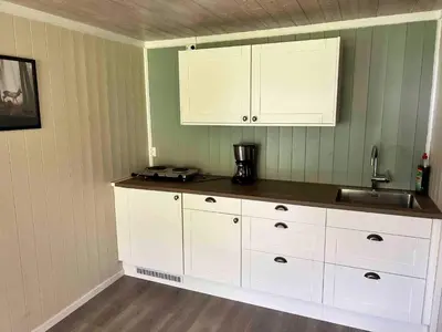 a kitchen with white cabinets and a sink at Dalsøren Camping og hytter in Luster