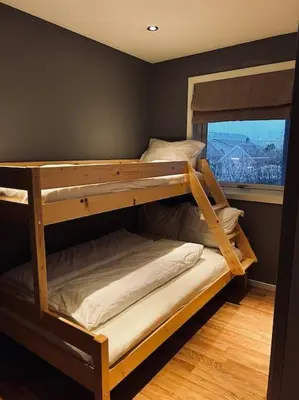 two bunk beds in a room with a window at Moderne rekkehus, god standard. in Ålesund