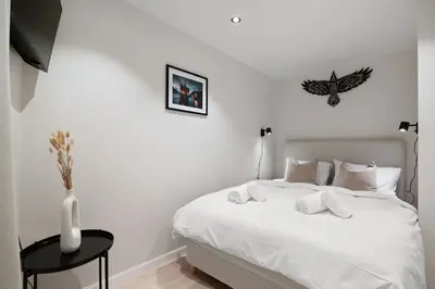 a bedroom with a white bed and a vase on a table at Renovated 2024 - Viking inspired - Behind bryggen in Bergen