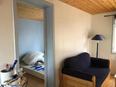 a bedroom with a blue chair and a bed and a mirror at Rena Hostel JOHANNES in Rena