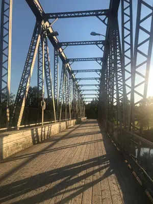 a bridge over a river with the sun shining at Rena Hostel JOHANNES in Rena