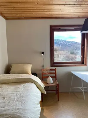 a bedroom with a bed and a window and a table at Spacious villa with view - 5BR - FREE parking - Great Wi-Fi in Bergen