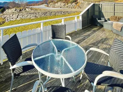a table and chairs on a deck with a pool at 6 person holiday home in Dalsøyra-By Traum in Dalsøyra