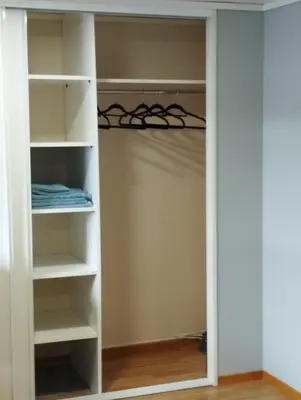 a walk in closet with white shelves at Sveciu namai in Vikedal