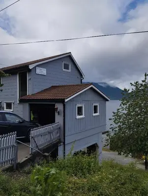 a blue house with a bench in front of it at Sveciu namai in Vikedal