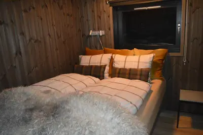 a bed with pillows on it in a room at Pow Panorama - High standard Mountain home in Sogndal