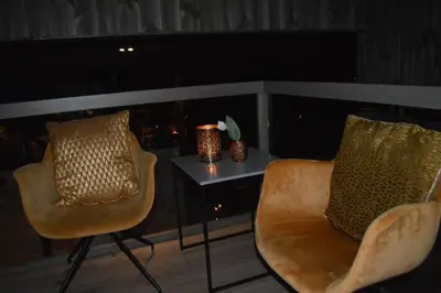 two chairs and a table with vases on a balcony at Pow Panorama - High standard Mountain home in Sogndal