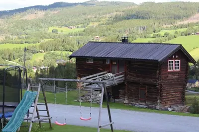 a playground with swings and a log cabin at Trevet by Norgesbooking - cabin close to skicenter in Ål