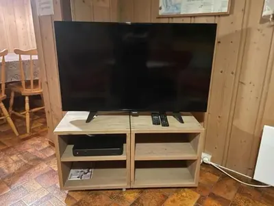 a flat screen tv sitting on a wooden stand at Trevet by Norgesbooking - cabin close to skicenter in Ål