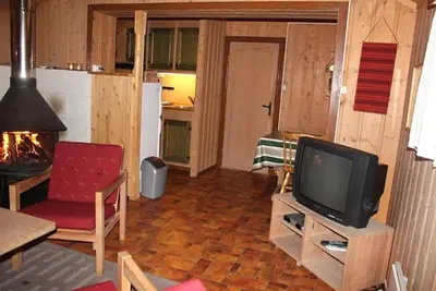 a living room with a tv and a red chair at Trevet by Norgesbooking - cabin close to skicenter in Ål