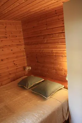 a bedroom with wooden walls and a bed with two pillows at Åkviktunet hytte nord in Averoy