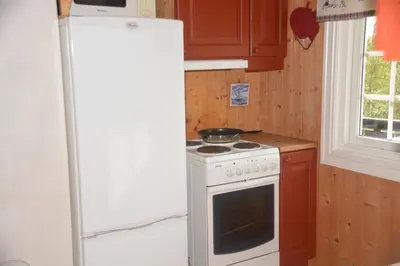 a kitchen with a white stove and a refrigerator at Einkjerrbu cabin by Norgesbooking - in Svingvoll