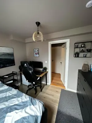 a bedroom with a bed and a desk with a computer at Modern Penthouse in Sandviken in Bergen