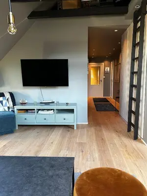 a living room with a flat screen tv on a wall at Modern Penthouse in Sandviken in Bergen