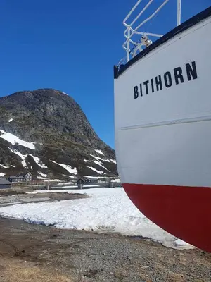 a white and red boat sitting next to a snow covered mountain at Fagerstrand, storhytte ved Bygdin i Jotunheimen in Beitostøl