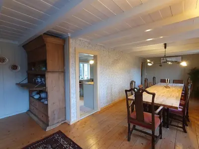 a dining room and kitchen with a wooden table and chairs at Fagerstrand, storhytte ved Bygdin i Jotunheimen in Beitostøl