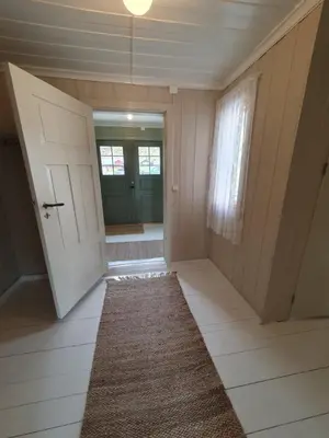 an empty hallway with a door and a rug at Fagerstrand, storhytte ved Bygdin i Jotunheimen in Beitostøl