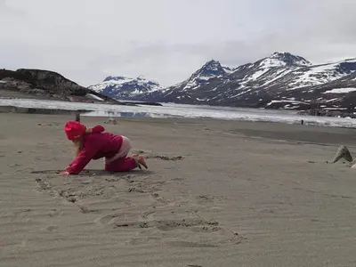 a child playing in the sand on the beach at Fagerstrand, storhytte ved Bygdin i Jotunheimen in Beitostøl