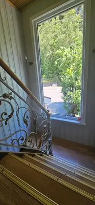 a balcony with a large window and a stair railing at Sveciu namai in Sandeid