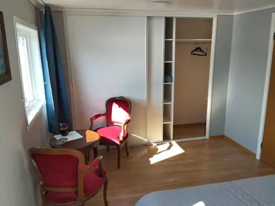 a room with two chairs and a table and a bed at Sveciu namai in Sandeid