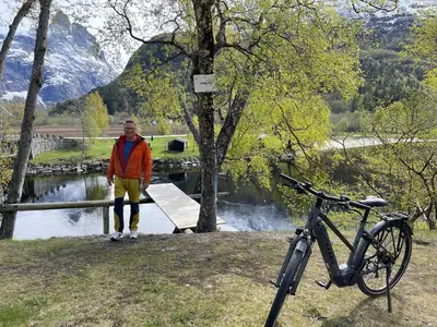 a man standing on a bridge next to a bike at Bakkebo Trollstigen in Åndalsnes