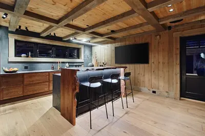 a kitchen with a bar and a flat screen tv at Chalet Strandafjellet in Stranda