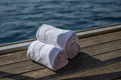 a stack of towels sitting on a table next to the water at New! Sea front apt. with terrace above the sea! in Bergen
