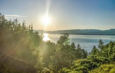 a view of a lake with the sun in the sky at 4 Bedroom Beautiful Home In Sekken in Molde