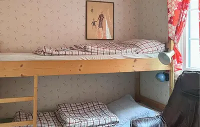 a bedroom with two bunk beds and a chair at 4 Bedroom Beautiful Home In Sekken in Molde