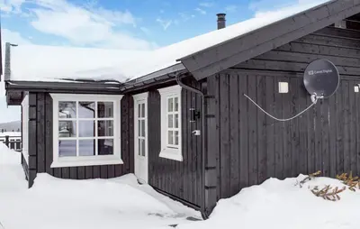 a wooden cabin in the snow with a balloon at 4 Bedroom Nice Home In Engerdal in Kvisla