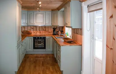 a kitchen with white cabinets and a wooden floor at 4 Bedroom Nice Home In Engerdal in Kvisla