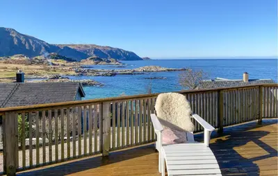 a white chair sitting on a deck overlooking the ocean at 2 Bedroom Lovely Home In Raudeberg in Raudeberg