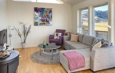 a living room with a couch and a table at 2 Bedroom Lovely Home In Raudeberg in Raudeberg
