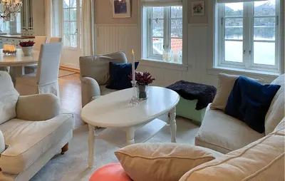 a living room with couches and a table with a candle at Amazing Home In Eiksund With Kitchen in Eiksund