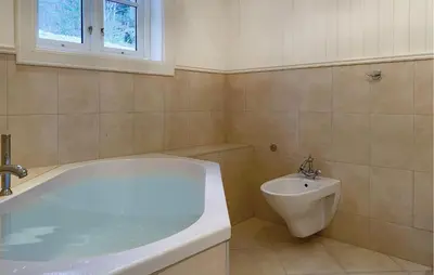a bathroom with a bath tub and a sink at Amazing Home In Eiksund With Kitchen in Eiksund